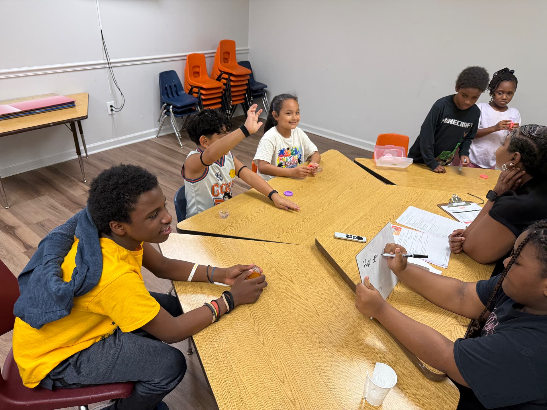 Kids and teen leaders talking around tables during ThriveKids