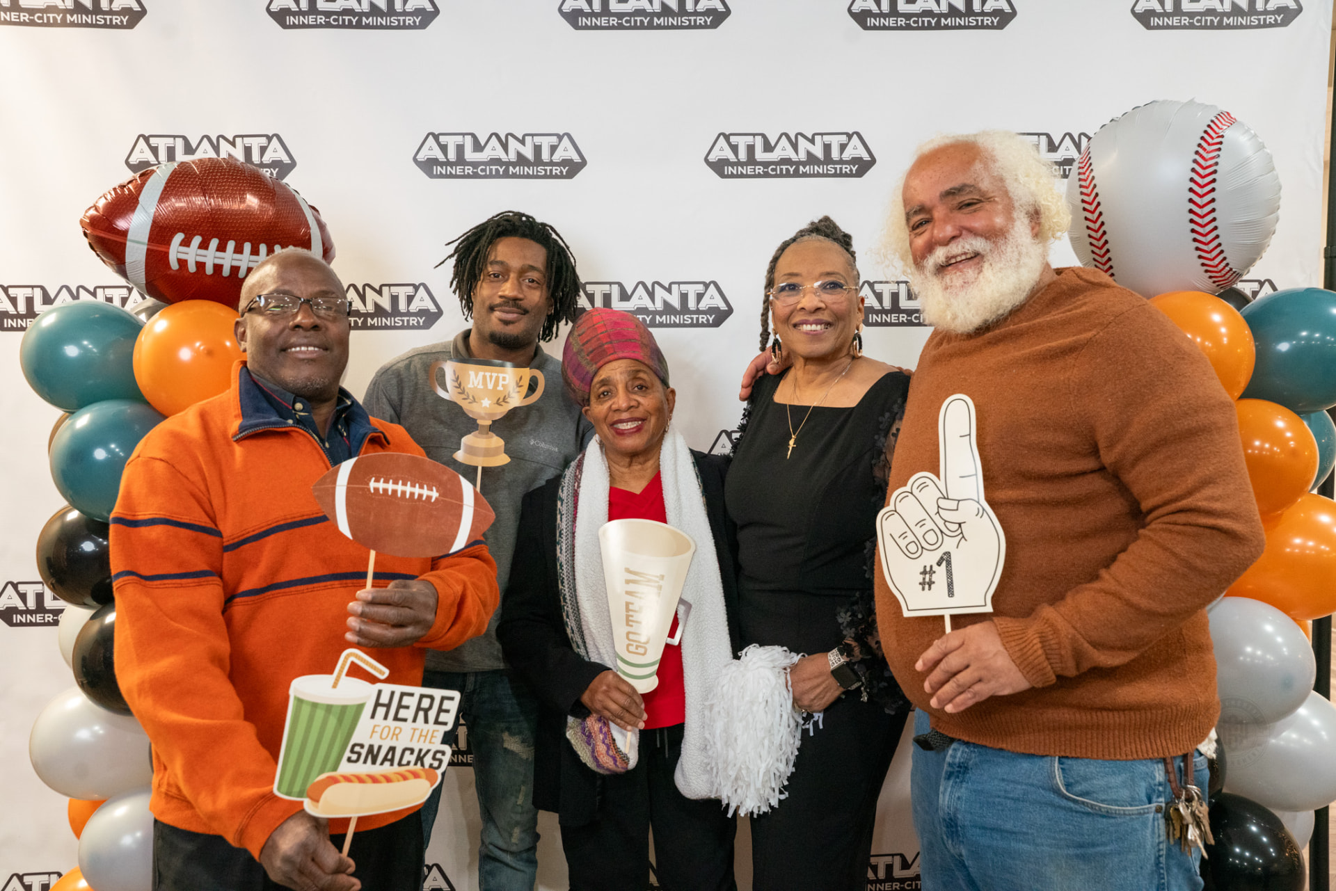 Guests posing with sports props at the AIM Victory Banquet photo booth
