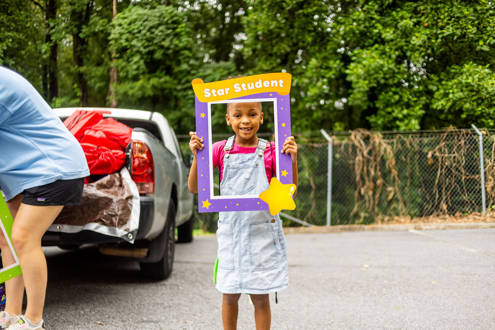 A student holding a Star Student frame outside after school