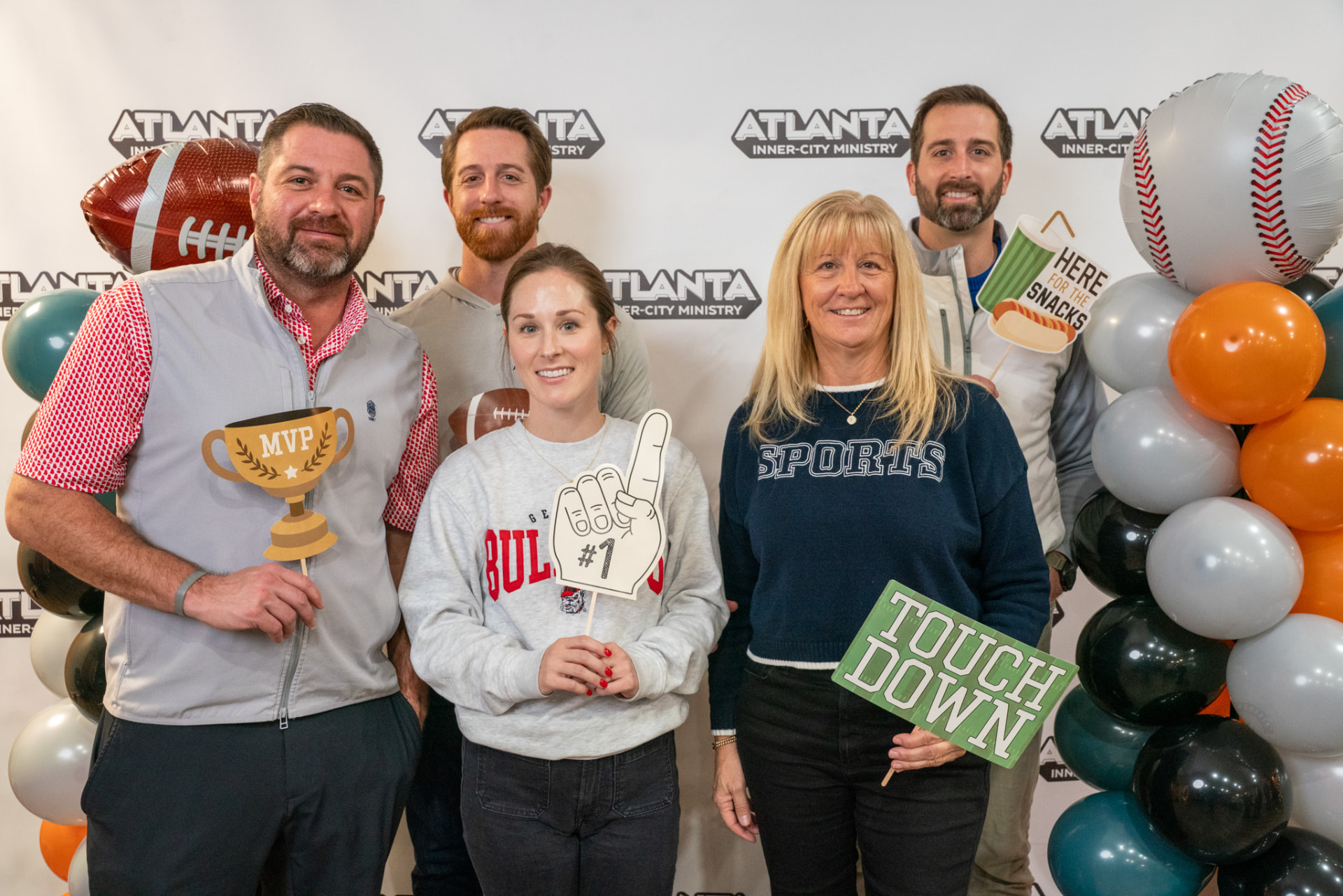 Guests holding sports props at the AIM Victory Banquet photo booth