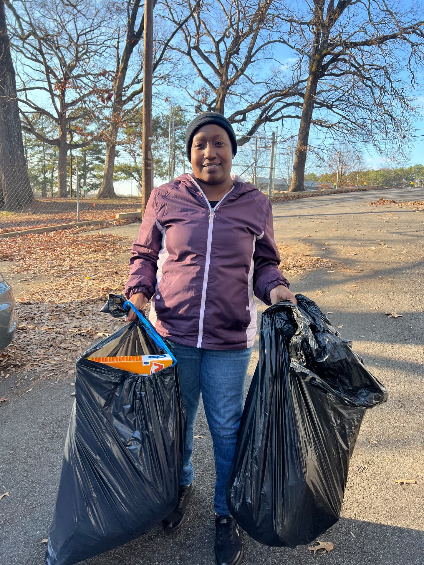 A parent carrying bags of Christmas gifts from AIM's Hope For The Family outreach