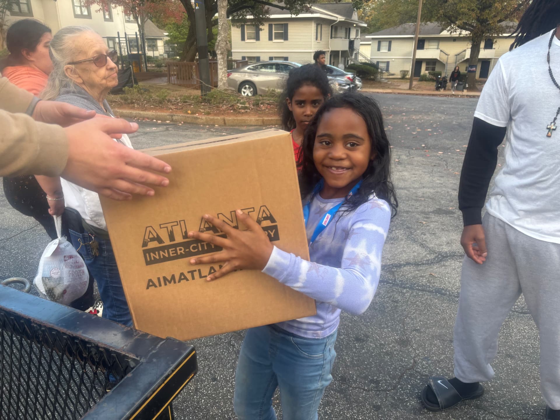 A girl receiving a Thanksgiving In A Box at an AIM distribution