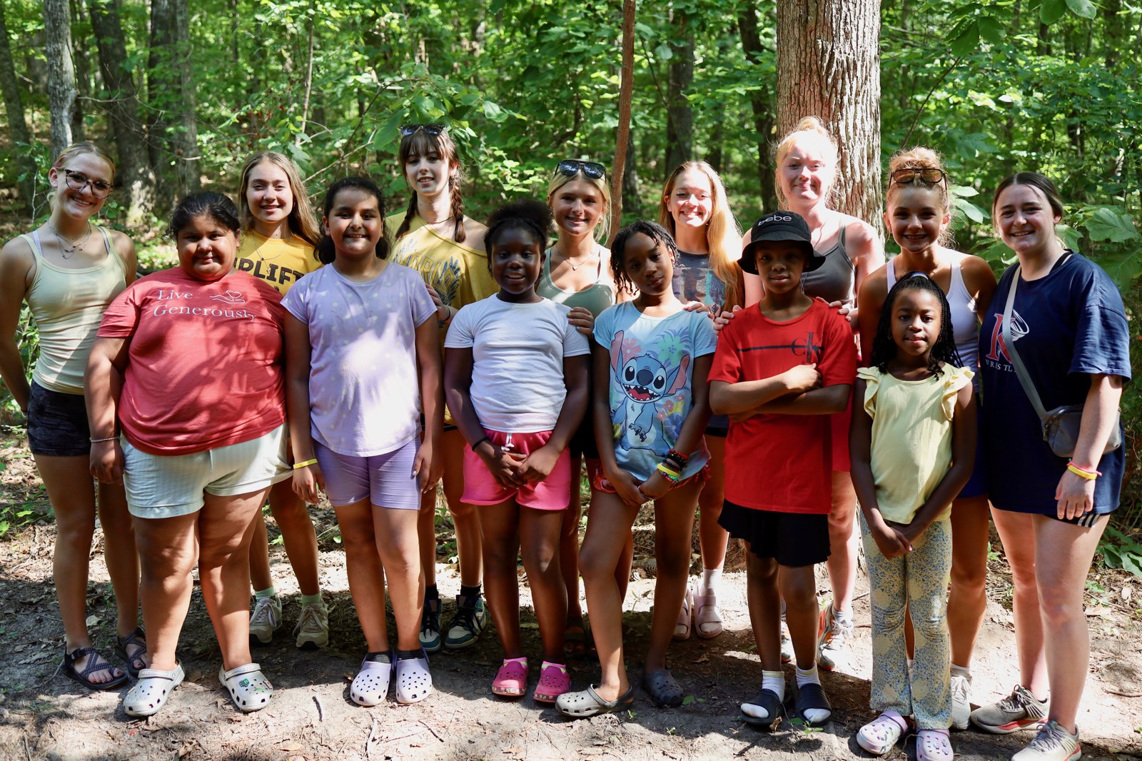 Campers laughing with counselors by the lake at AIMCamp