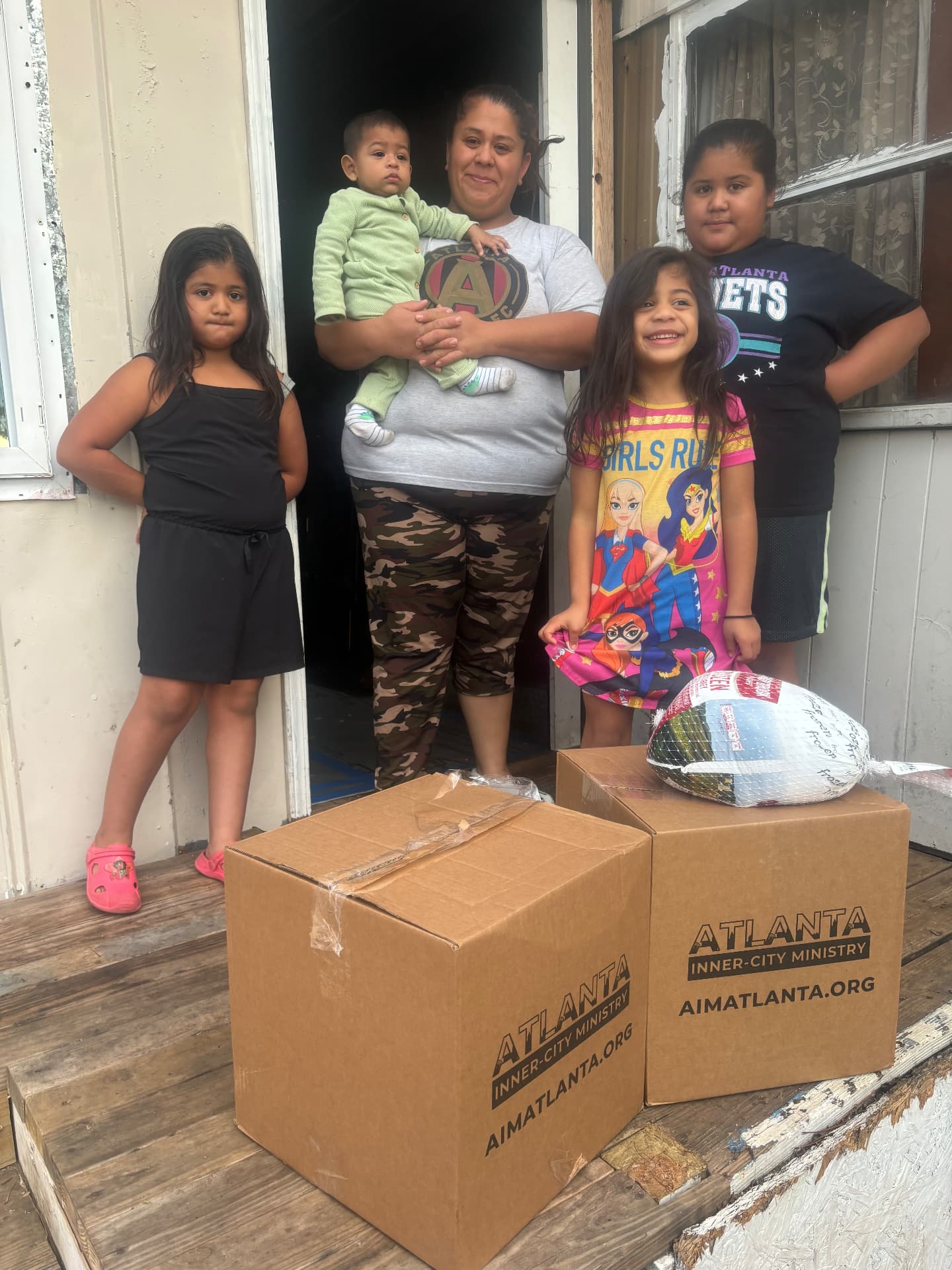 A family on their doorstep with two Thanksgiving In A Box meals